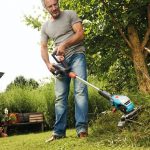 homme en jean avec son coupe-bordure