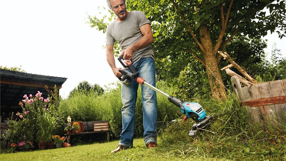 homme en jean avec son coupe-bordure